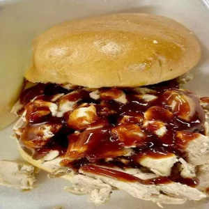 Photo of one of our Sandwiches, served on a grilled brioche bun w/choice of sauce Choice of: Pulled Pork, Pulled Chicken, Pulled Beef or Homemade Smoked Kielbasa.